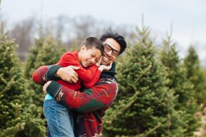 Christmas tree farm backdrop with father and son laughing